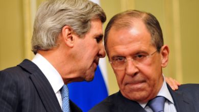 US Secretary of State John Kerry whispers to his Russian counterpart Sergei Lavrov