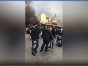"ثورة ثورة".. هتافات محتجين قطعوا السير تحت جسر الكولا في بيروت بالإطارات المشتعلة (فيديو)