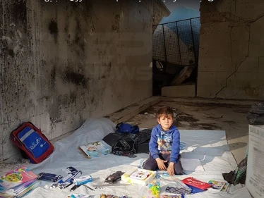 طفل مهجر من مدينة البوكمال بريف دير الزور يبيع أغراض مدرسية على خيمة للأمم المتحدة