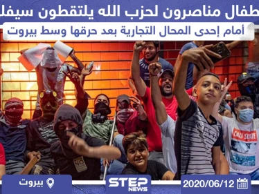أطفال مناصرون لميليشيا حزب الله يلتقطون سيلفي أمام إحدى المحال التجارية بعد حرقها وسط بيروت
