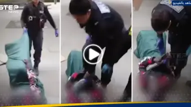 شاهد|| شرطية بريطانية تعتدي على لاجئ عربي بالضرب وتركله في بطنه وسط الشارع