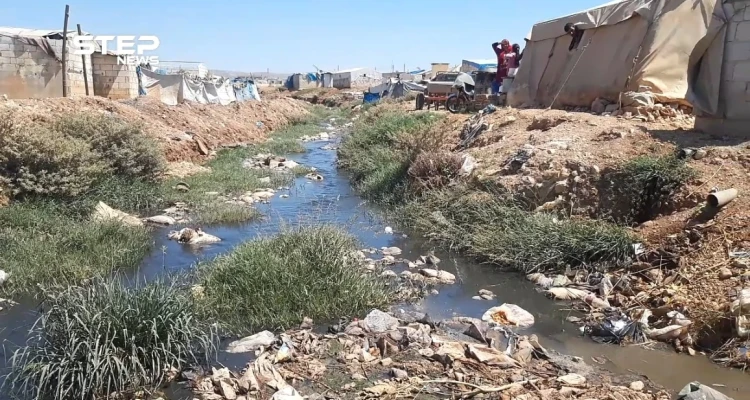 إضافة إلى ألم النزوح .. خيامهم على ضفاف قناة الصرف الصحي في أطمة بريف إدلب